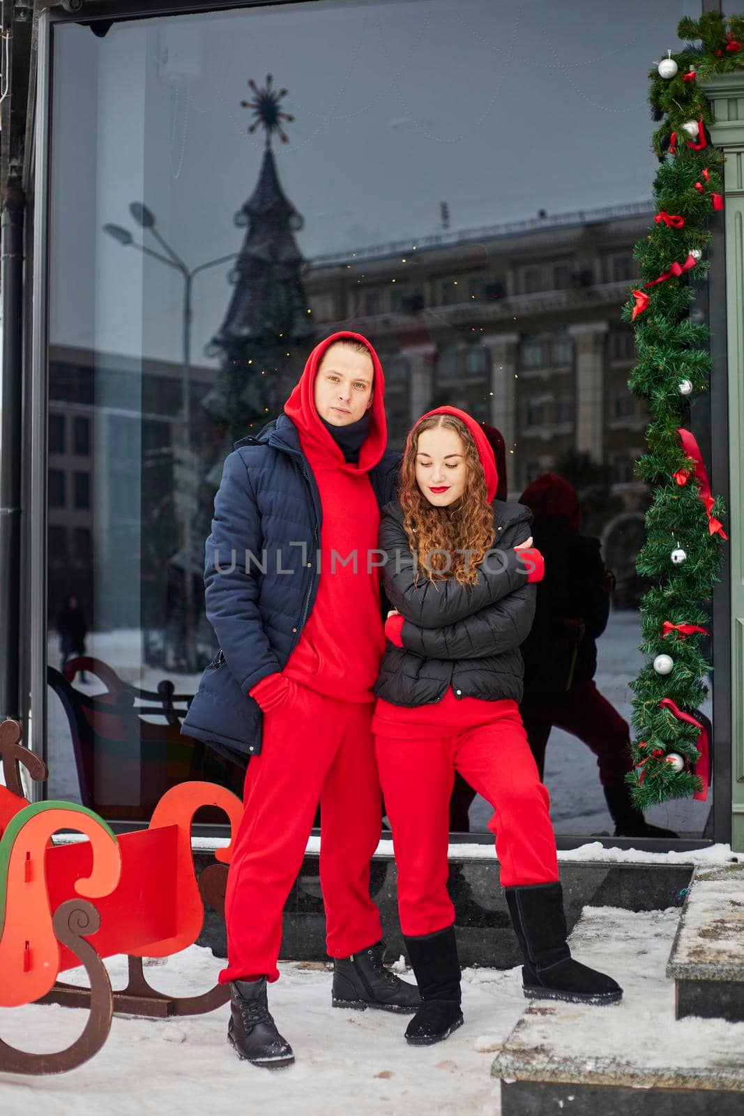 young happy family, a guy and a girl spend the day near the cafe, the guy hugs the girl