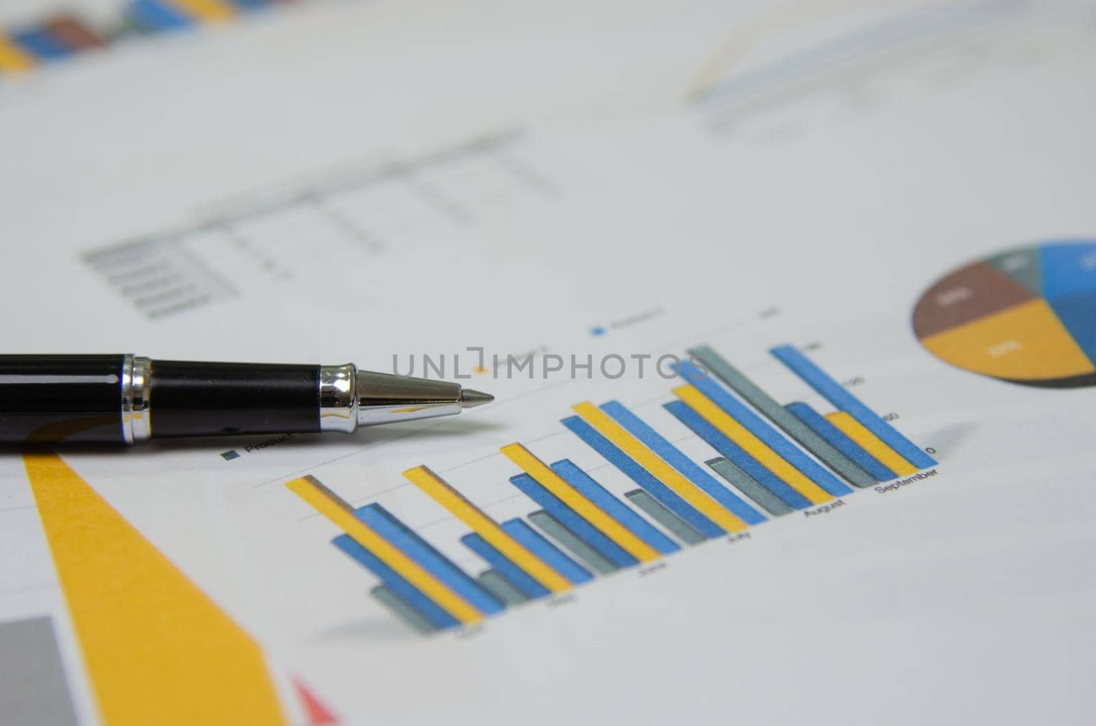 Business document reports graphics and charts and pen on paperwork financial statistics growth investment account planning analysis at office.