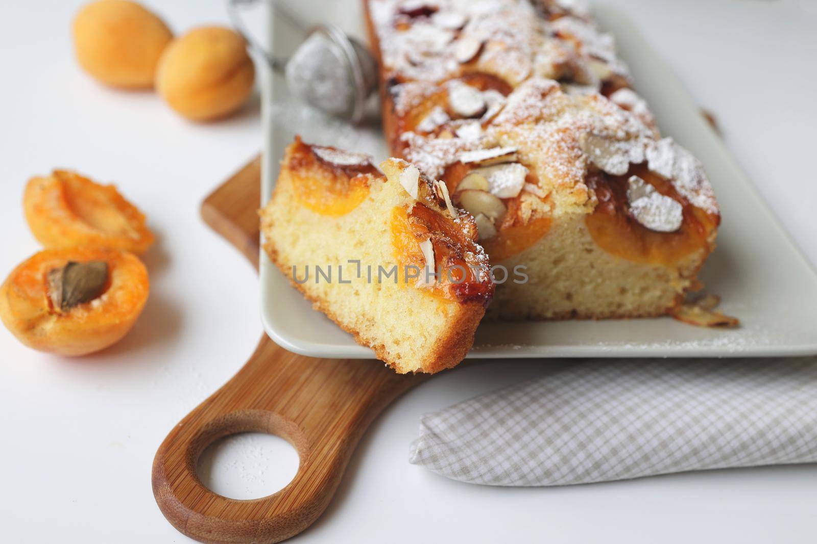 rectangular appetizing homemade apricot pie on a rectangular plate. Cut portion piece close-up.