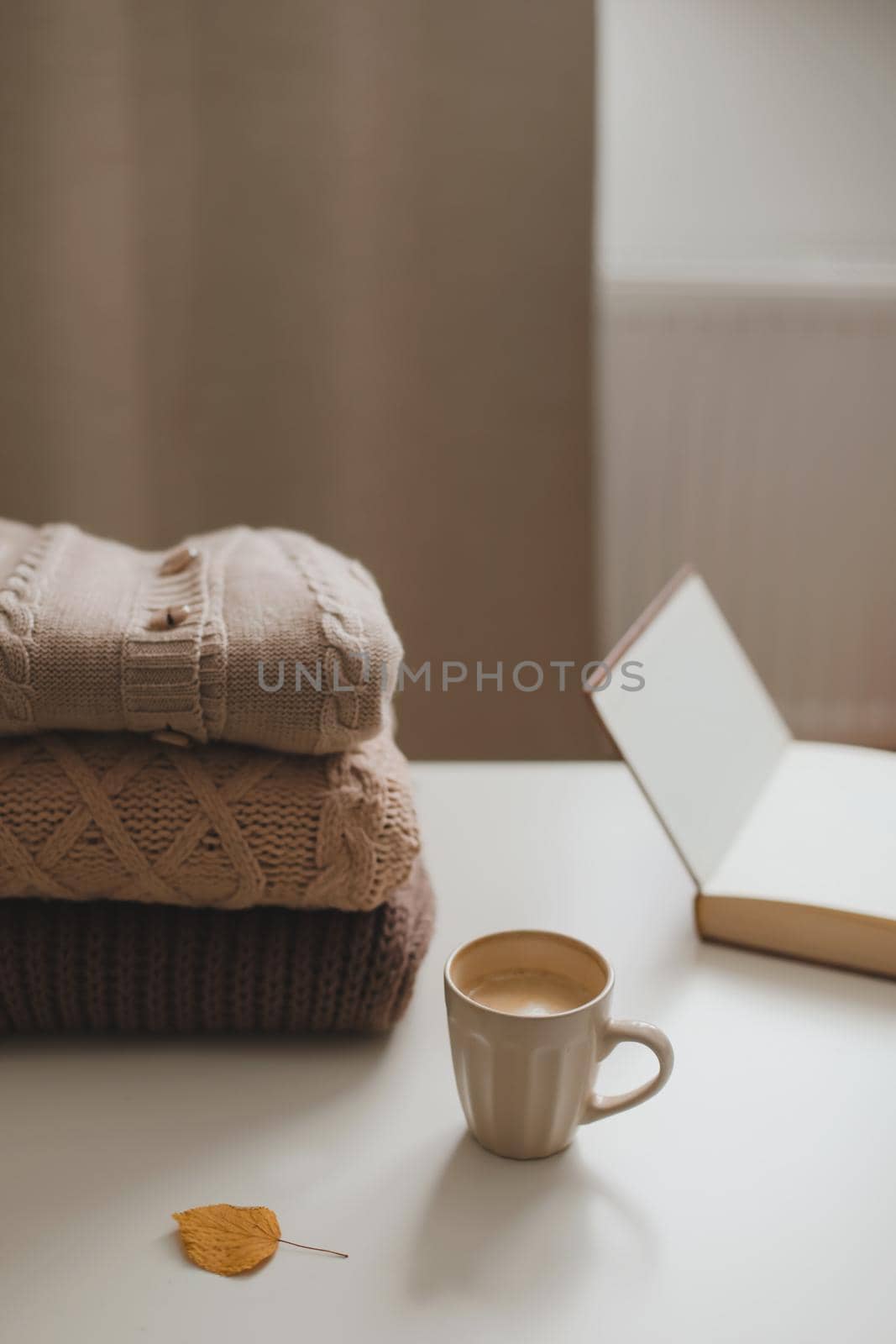 cozy comfortable winter and autumn home atmosphere and still life with a cup, book and warm sweaters by paralisart