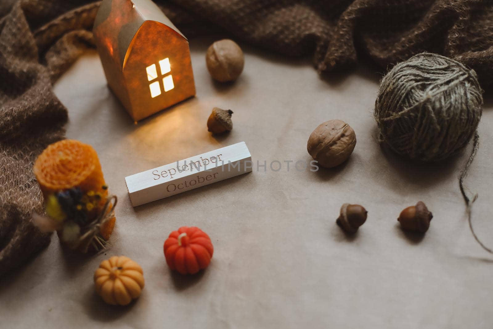 Autumn still life details in cozy home interior with a cup, candles, plaid. Hygge home decor. Halloween and Thanksgiving concept. Autumn banner