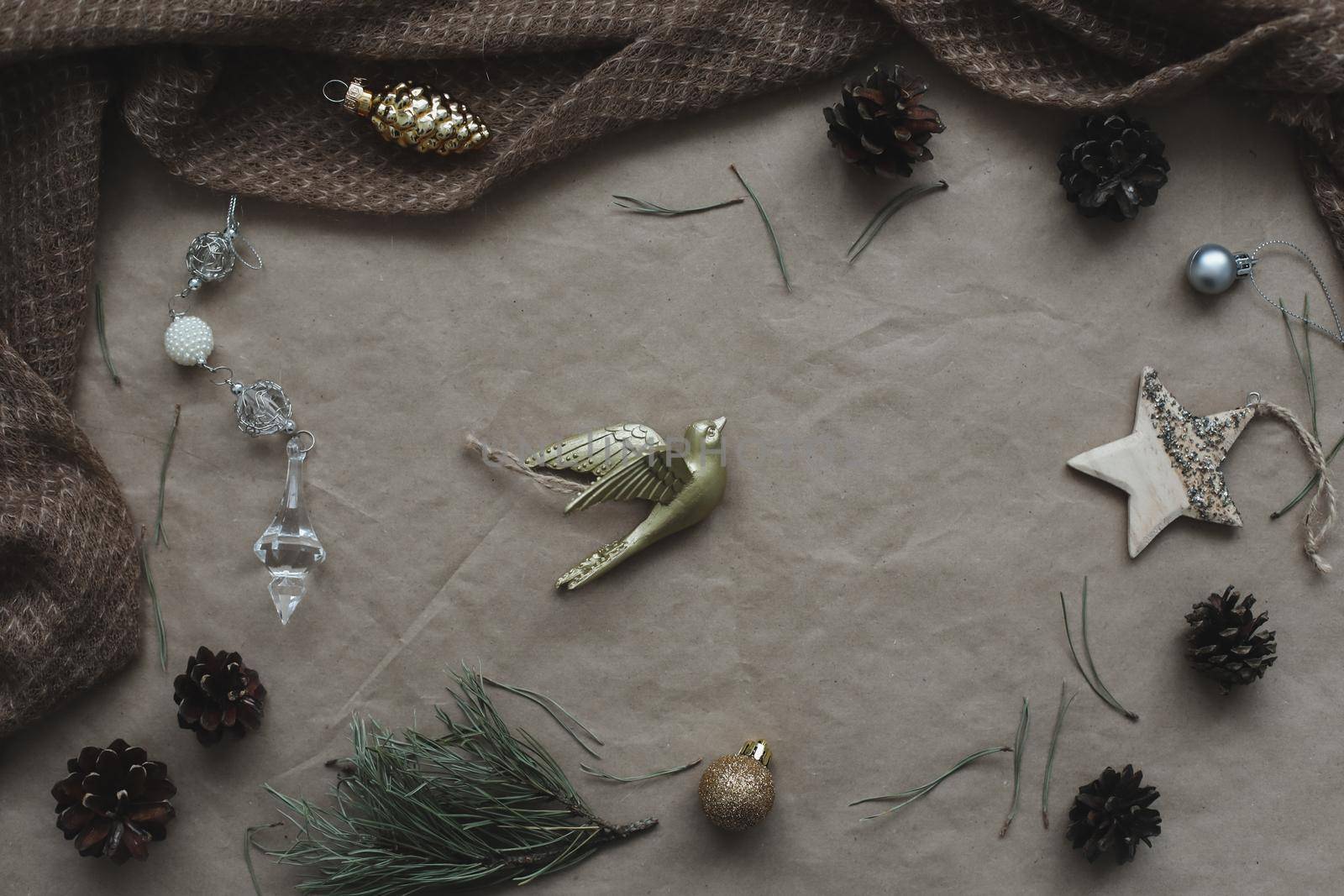 Christmas composition on craft paper background with gift box, fir branches, toys, copy space for your congratulations.