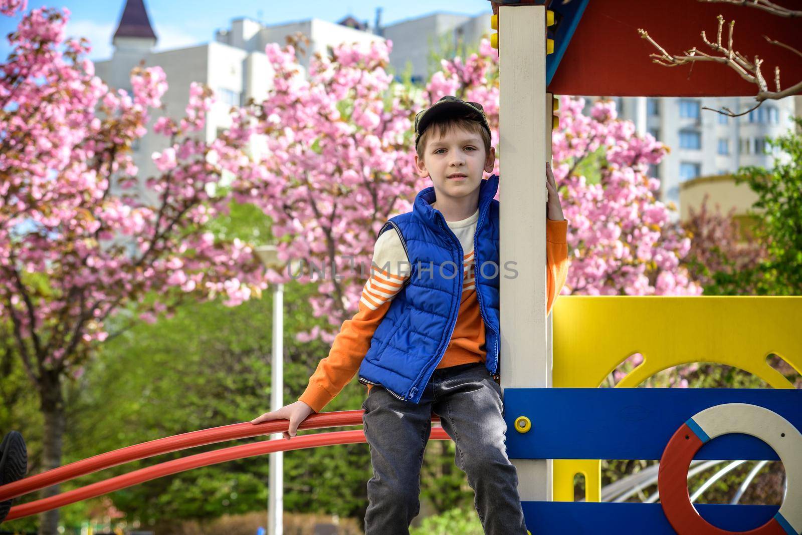 Portrait of cute boy playing at playground on sunny morning. Leisure with children concept by Kobysh
