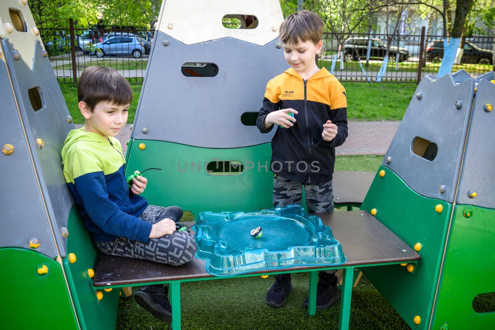 Two Boys playing with modern spin top outdoors. Entertainment ga by Kobysh