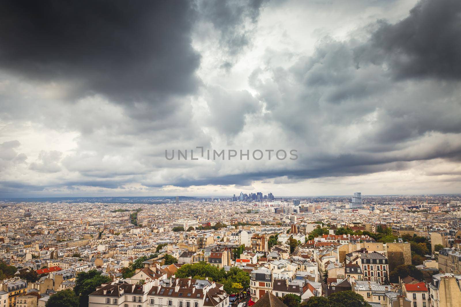 Panoramic view above Paris from Sacre Couer in Montmartre with dramatic storm clouds sky, France