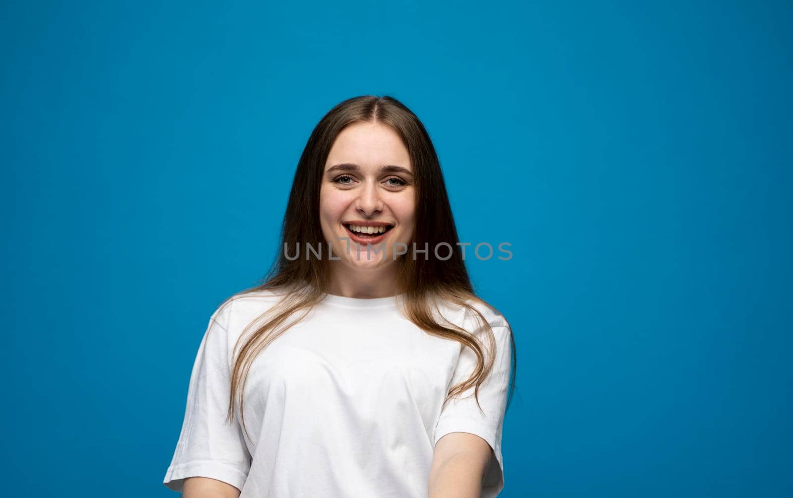 Attractive woman with long hair being very glad smiling with broad smile showing her teeth and having fun indoors. Joyful excited cheery female