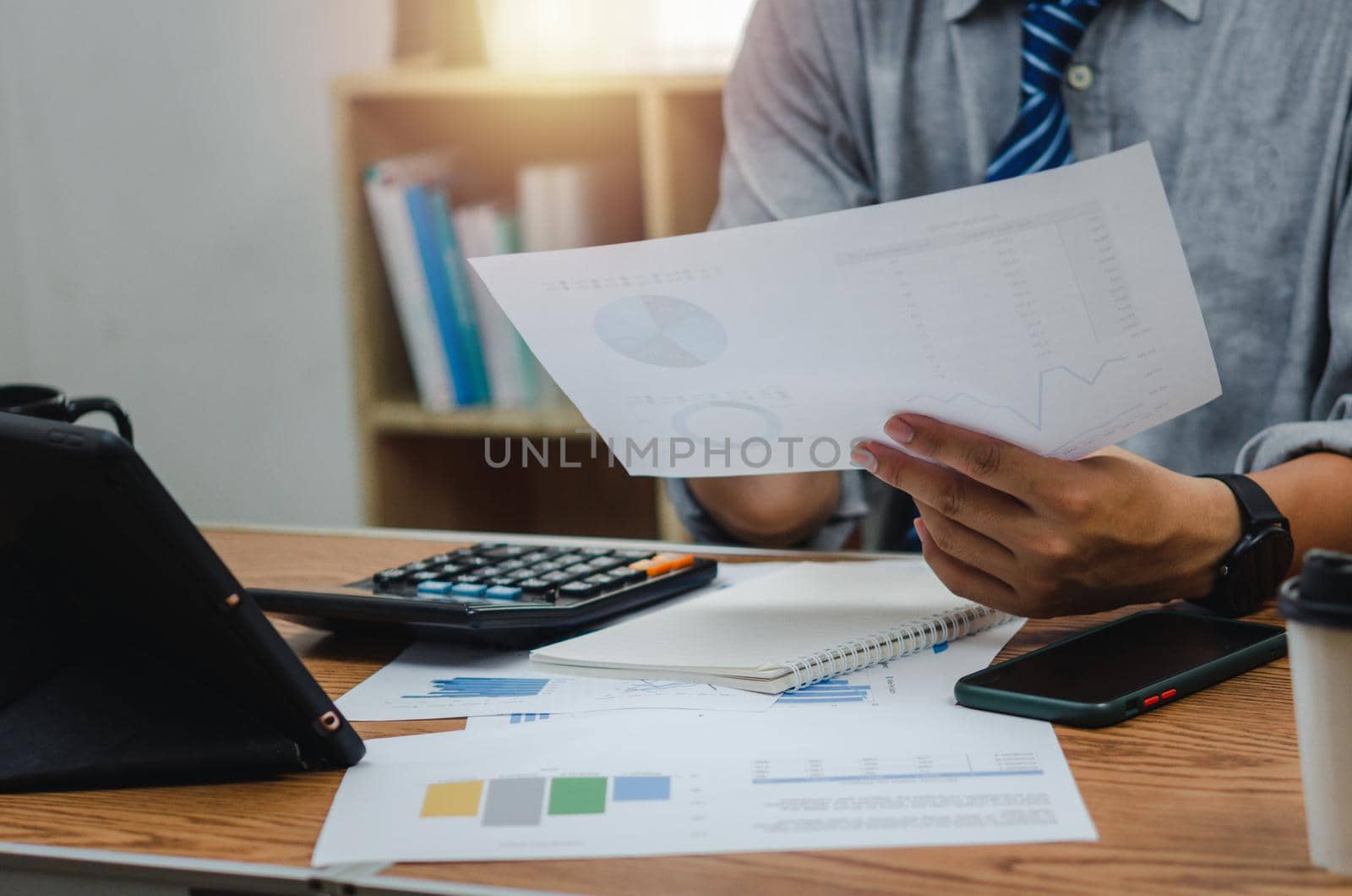Businessman holding paperwork document graph report accounting and finance investment on desk. by aoo3771
