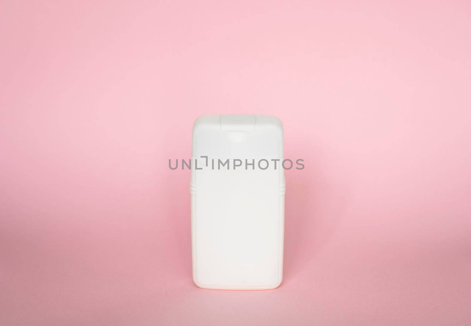 White plastic bottle of body care and beauty products. Studio photography of plastic bottle for shampoo, shower gel, creme isolated on pink background. by vovsht