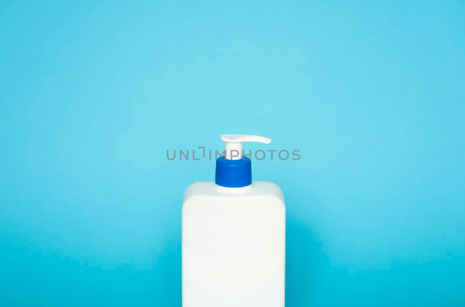 Liquid container for gel, lotion, cream, shampoo, bath foam. Cosmetic plastic bottle with dispenser pump on pink background. Cosmetic packaging mockup with copy space