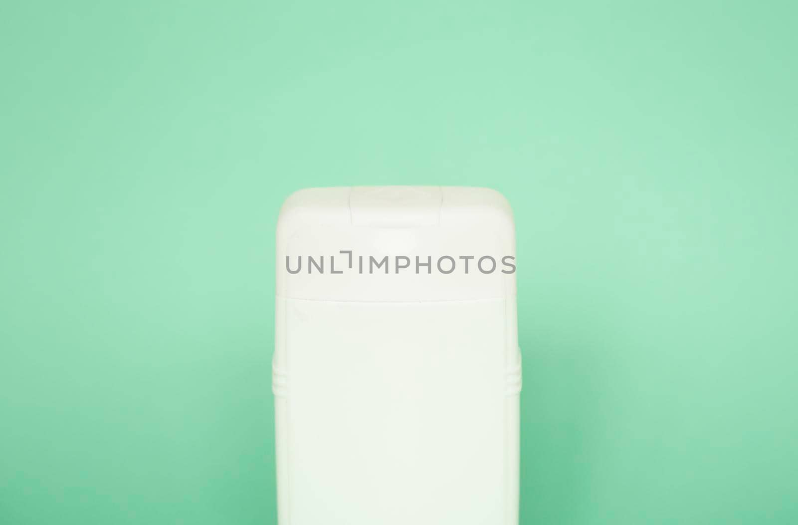 White plastic shampoo bottle isolated on green background. Skin care lotion. Bathing essential product. Shampoo bottle. Bath and body lotion. Fine liquid hand wash. by vovsht