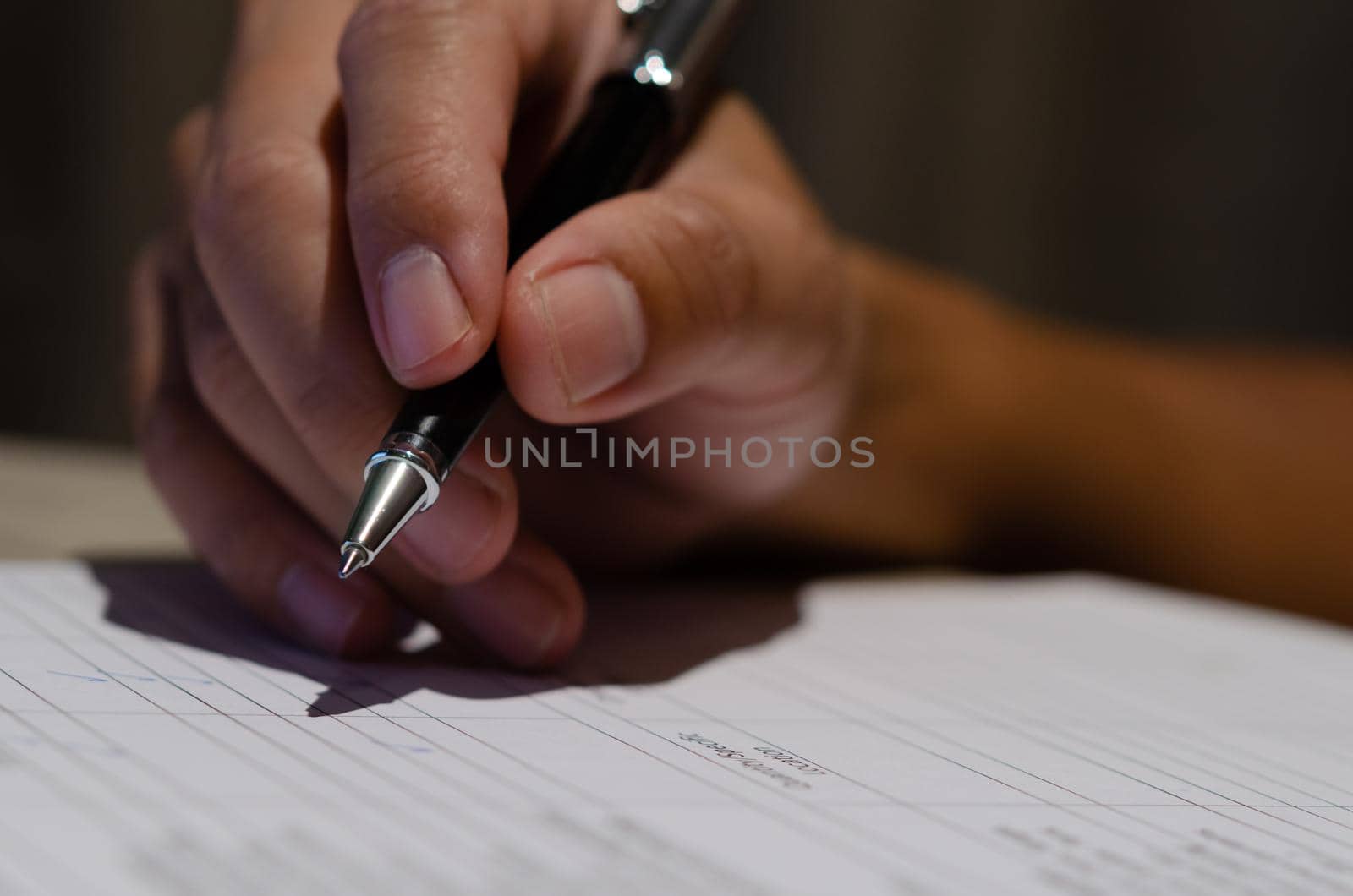 Businessman holding pen signature contract document finance investment or paperwork report on desk.