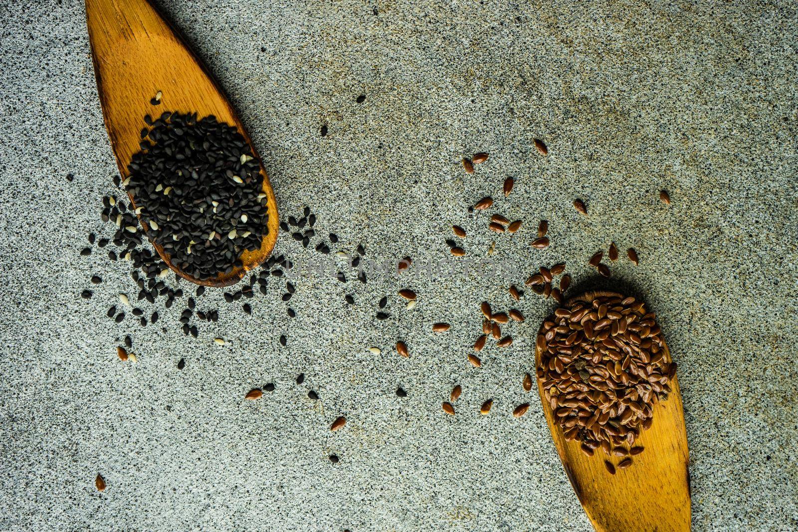 Overhead view of vintage wooden spoons with black sesame and flax seeds