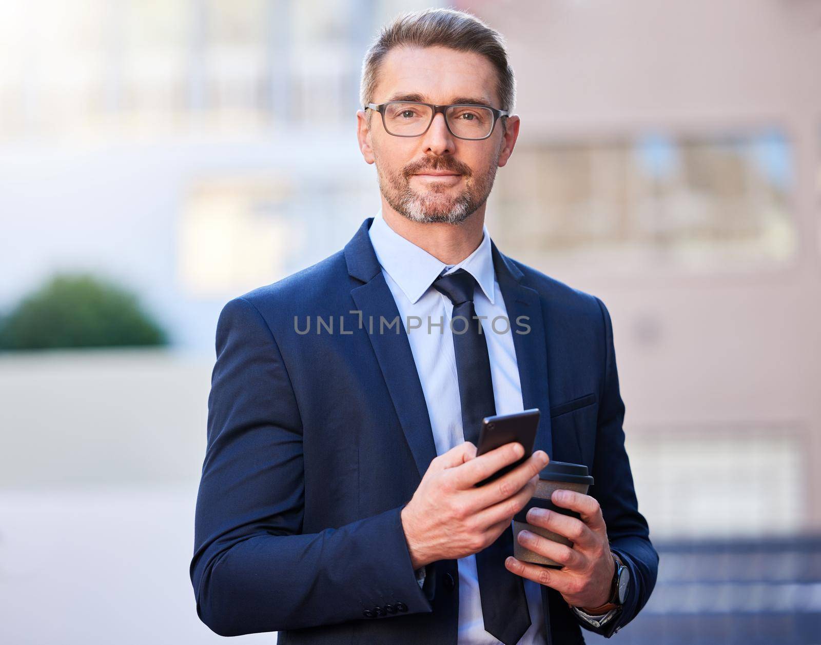 Communication keeps me ahead of the game. Cropped portrait of a handsome mature businessman standing outside in the city. by YuriArcurs
