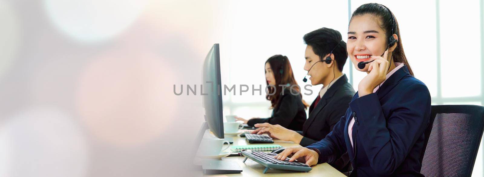 Business people wearing headset working in office in widen view to support remote customer or colleague. Call center, telemarketing, customer support agent provide service on telephone video call.