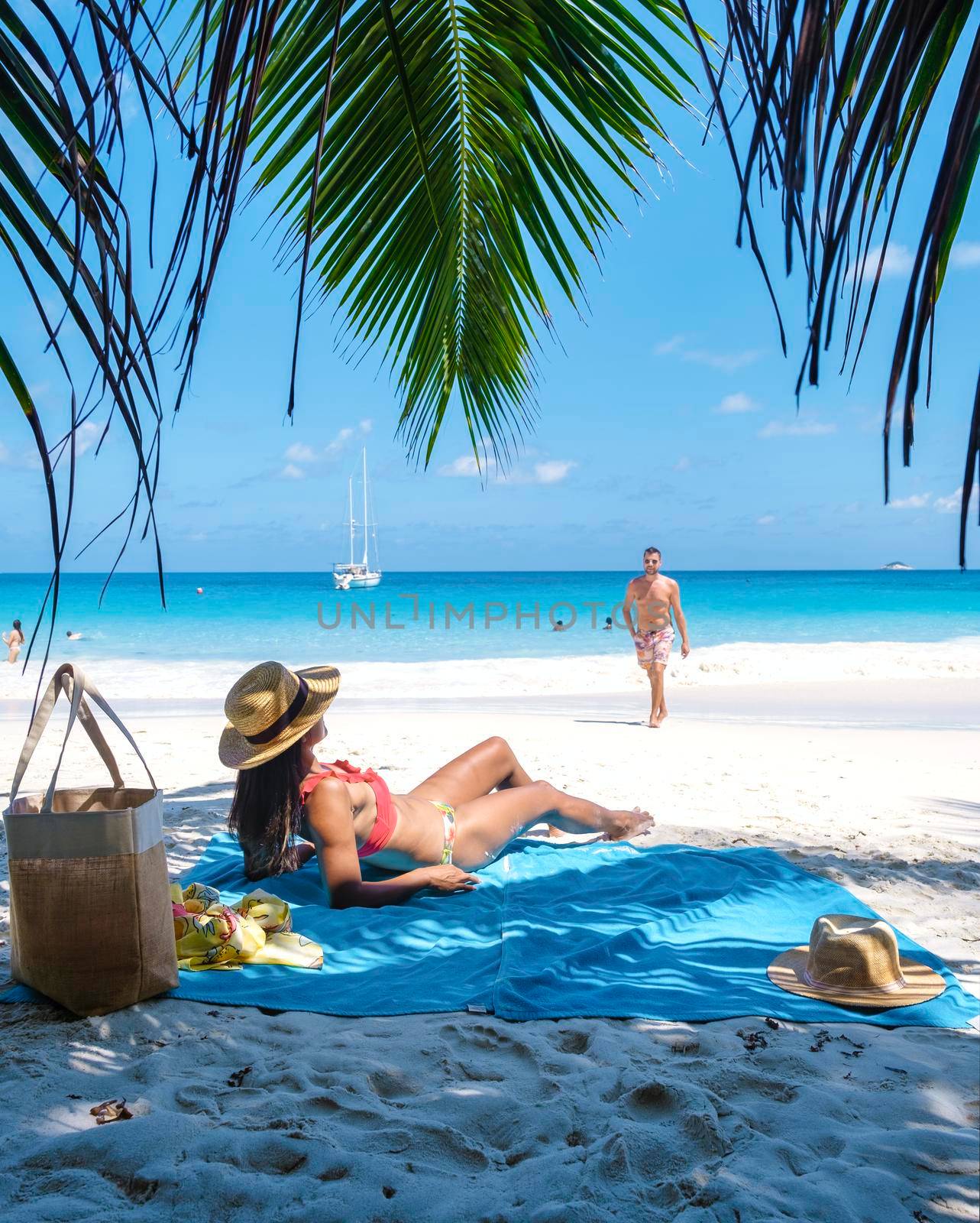 Anse Lazio Praslin Seychelles, couple men and woman on a tropical beach during a luxury vacation by fokkebok