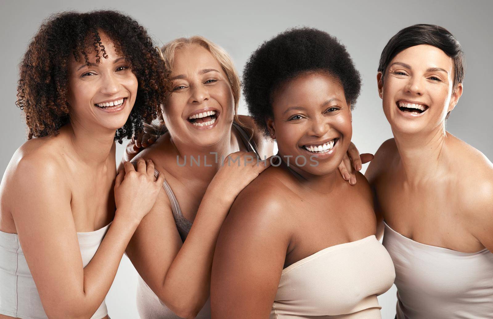 Were taking beauty to the next level. a diverse group of women standing and hugging each other in the studio. by YuriArcurs