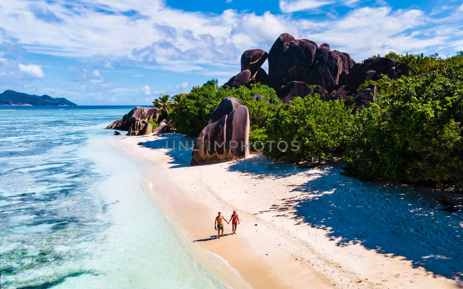 Anse Source d'Argent, La Digue Seychelles, a young couple of Caucasian men and Asian women on a tropical beach during a luxury vacation in Anse Source d'Argent, La Digue Seychelles