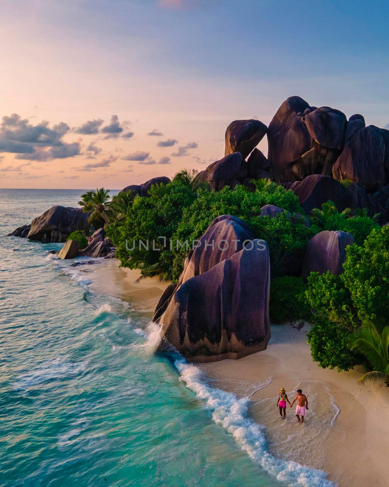 Anse Source d'Argent, La Digue Seychelles, a young couple of Caucasian men and Asian women on a tropical beach during a luxury vacation in Anse Source d'Argent, La Digue Seychelles