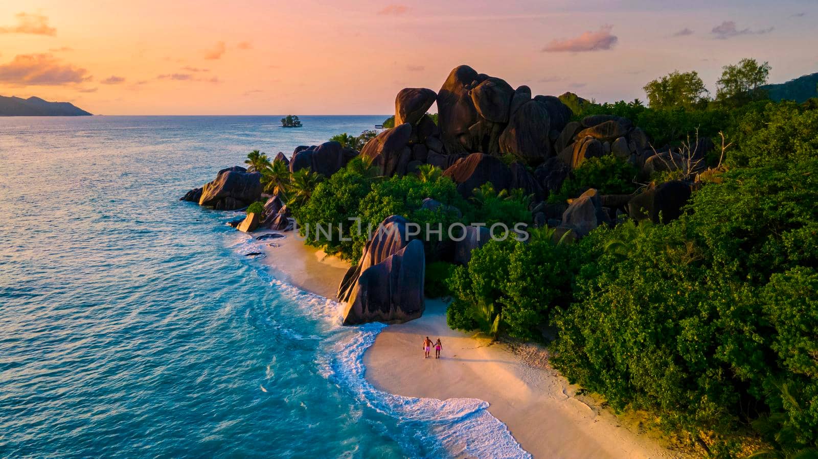 Anse Source d'Argent, La Digue Seychelles, a young couple of Caucasian men and Asian women on a tropical beach during a luxury vacation in Anse Source d'Argent, La Digue Seychelles