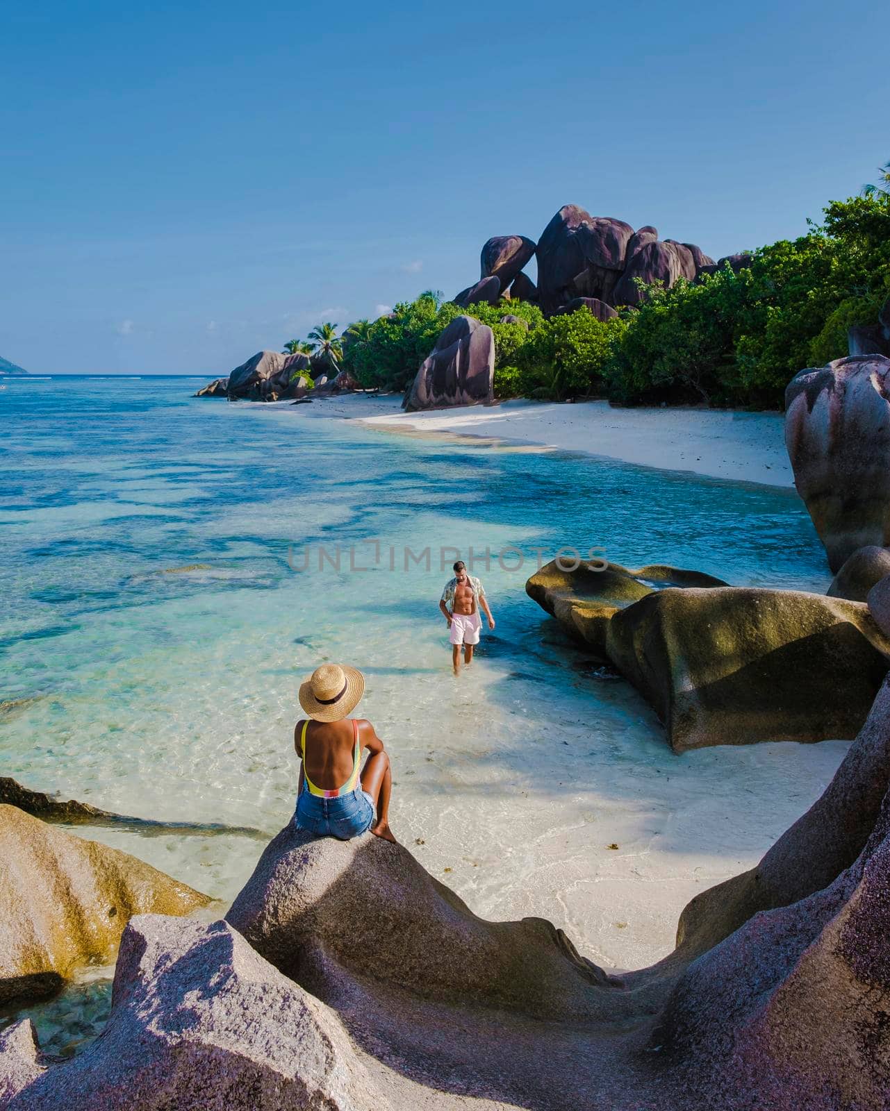 Anse Source d'Argent, La Digue Seychelles, a young couple of Caucasian men and Asian women on a tropical beach during a luxury vacation in Anse Source d'Argent, La Digue Seychelles