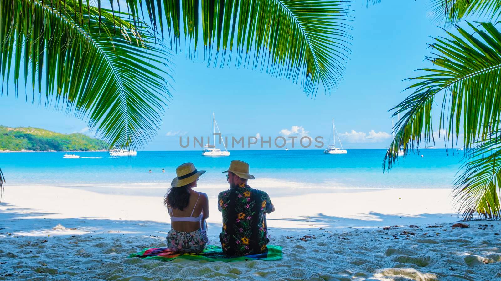 Anse Lazio Praslin Seychelles, couple men and woman on a tropical beach during a luxury vacation by fokkebok