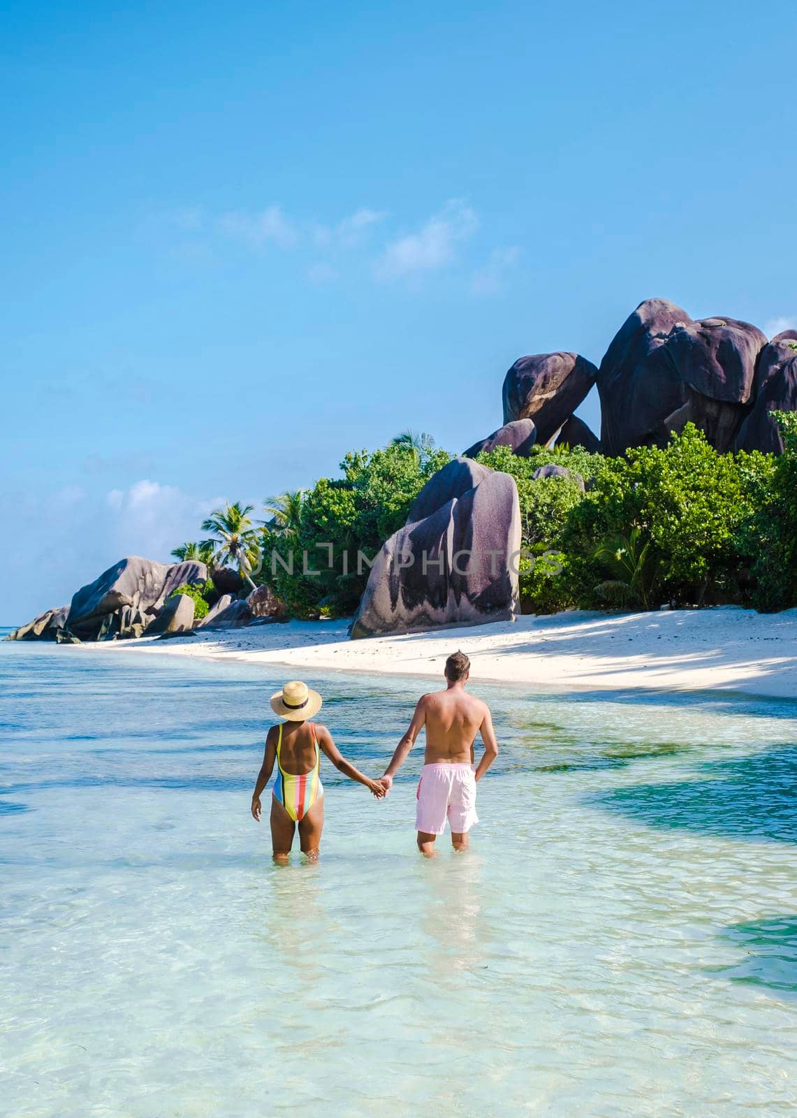 Anse Source d'Argent, La Digue Seychelles, a young couple of Caucasian men and Asian women on a tropical beach during a luxury vacation in Anse Source d'Argent, La Digue Seychelles