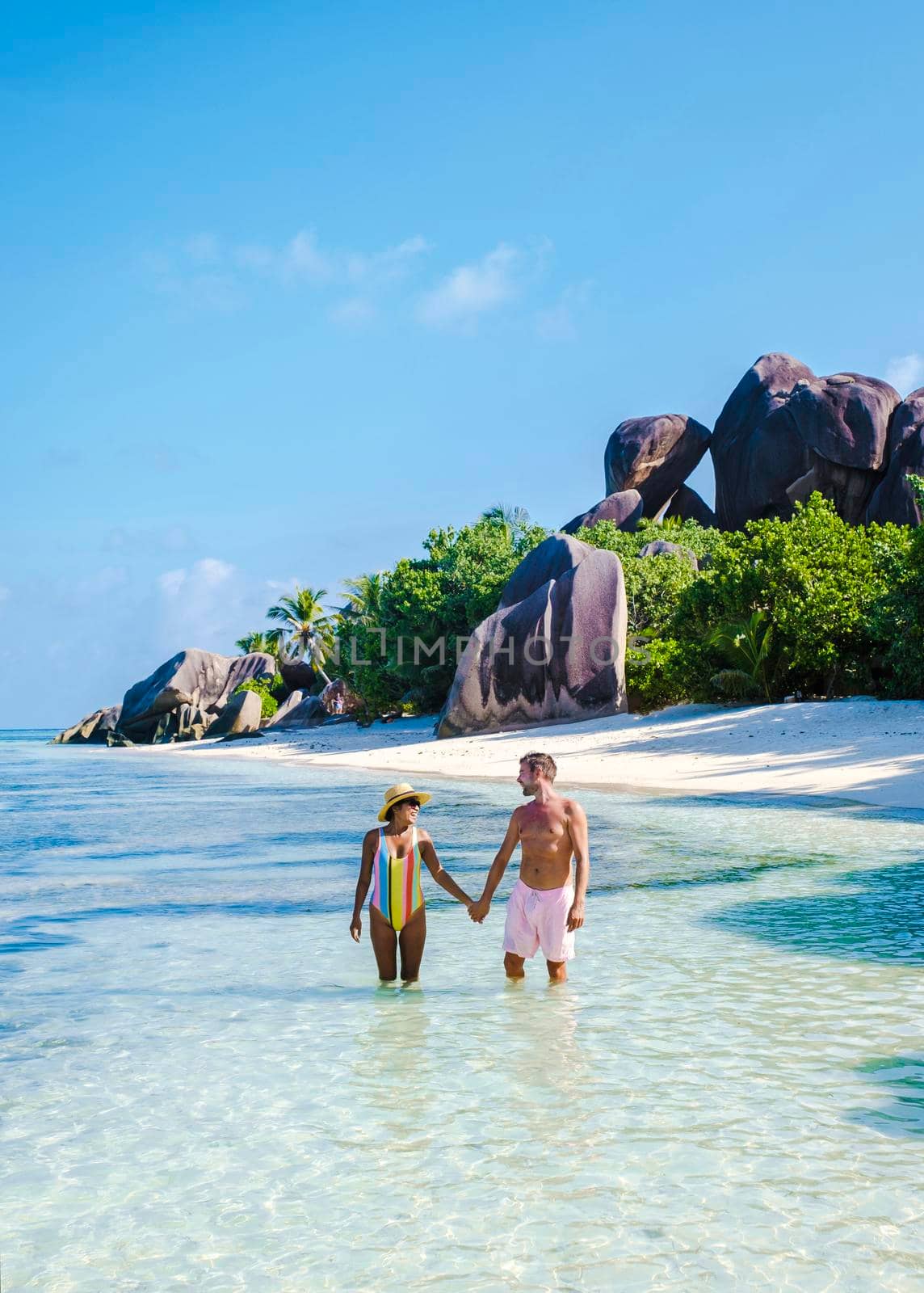 Anse Source d'Argent, La Digue Seychelles, a young couple of Caucasian men and Asian women on a tropical beach during a luxury vacation in Anse Source d'Argent, La Digue Seychelles