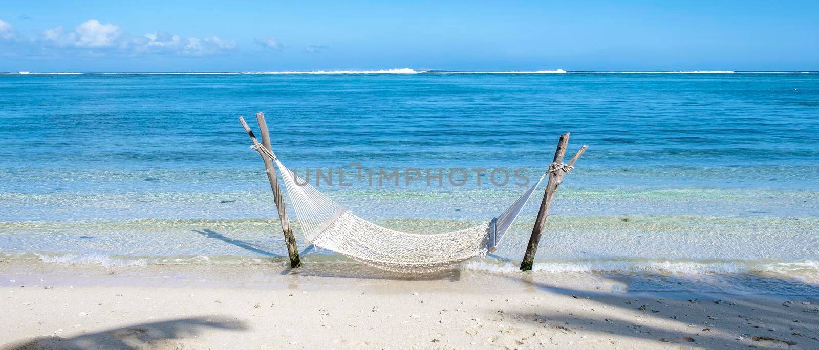 tropical beach with hammock in the ocean, white sandy beach with hammock Le Morne beach Mauritius.