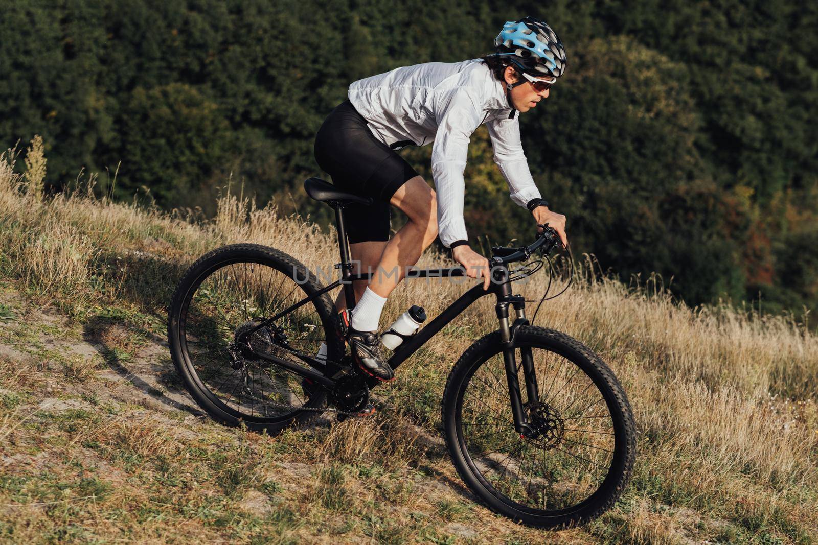 Equipped Professional Cyclist Descends a Slope on Mountain Bike, Sportsman Going Down from Hill on Bicycle