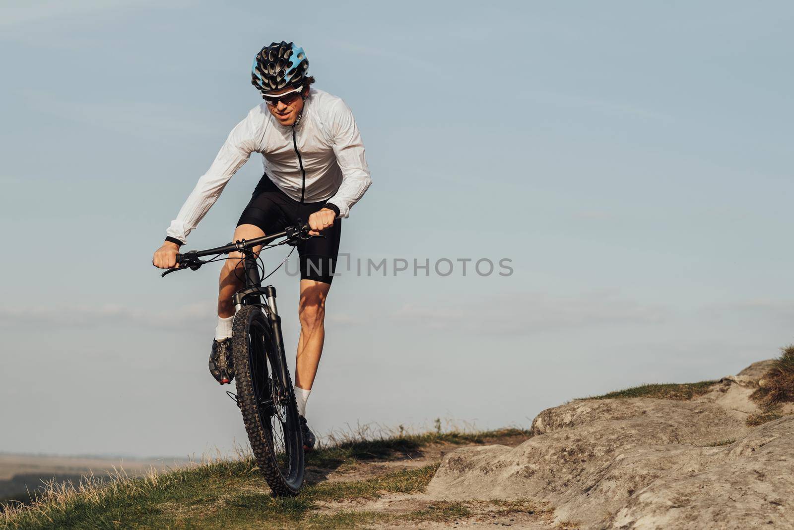 Professional Male Cyclist Riding Bike, Adult Equipped Man on Bicycle on Top of Hill, Copy Space on the Sky Background