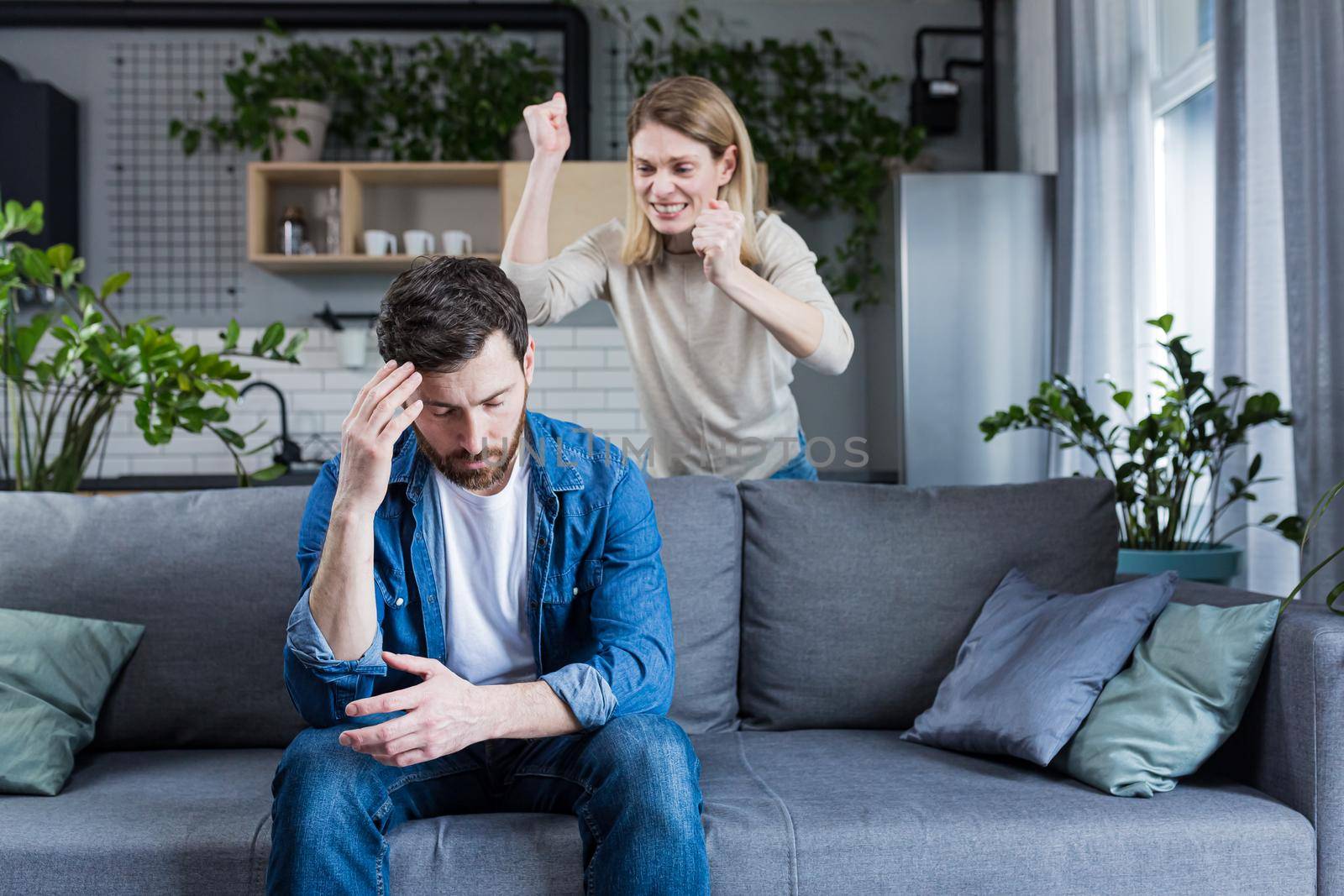 Young family, couple at home, man and woman quarrel, conflict, woman shouting and waving by voronaman