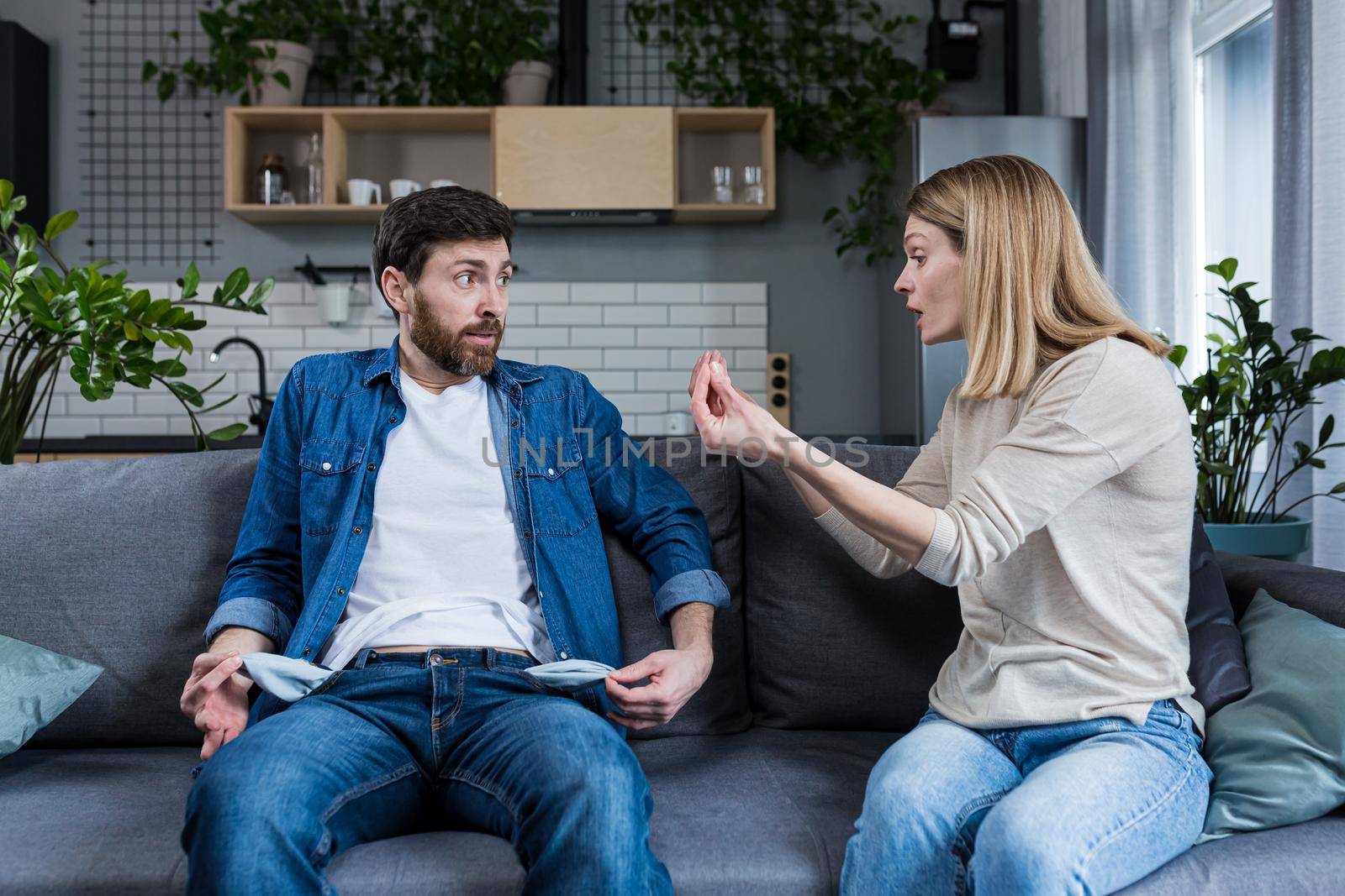 A woman quarrels with her husband, the claim of a lazy man who earns little money, a married couple quarrels sitting on the couch