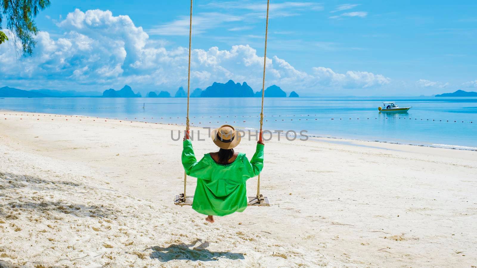 woman on the beach in a swing of the tropical Island Naka Island near Phuket Thailand by fokkebok