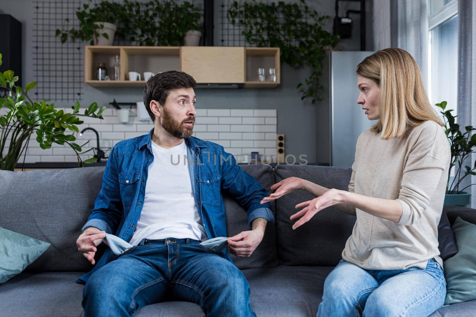 A young woman demands money from her husband, the man does not show empty pockets. At home, sitting on the couch. Quarrels, conflicts, misunderstandings. Money crisis