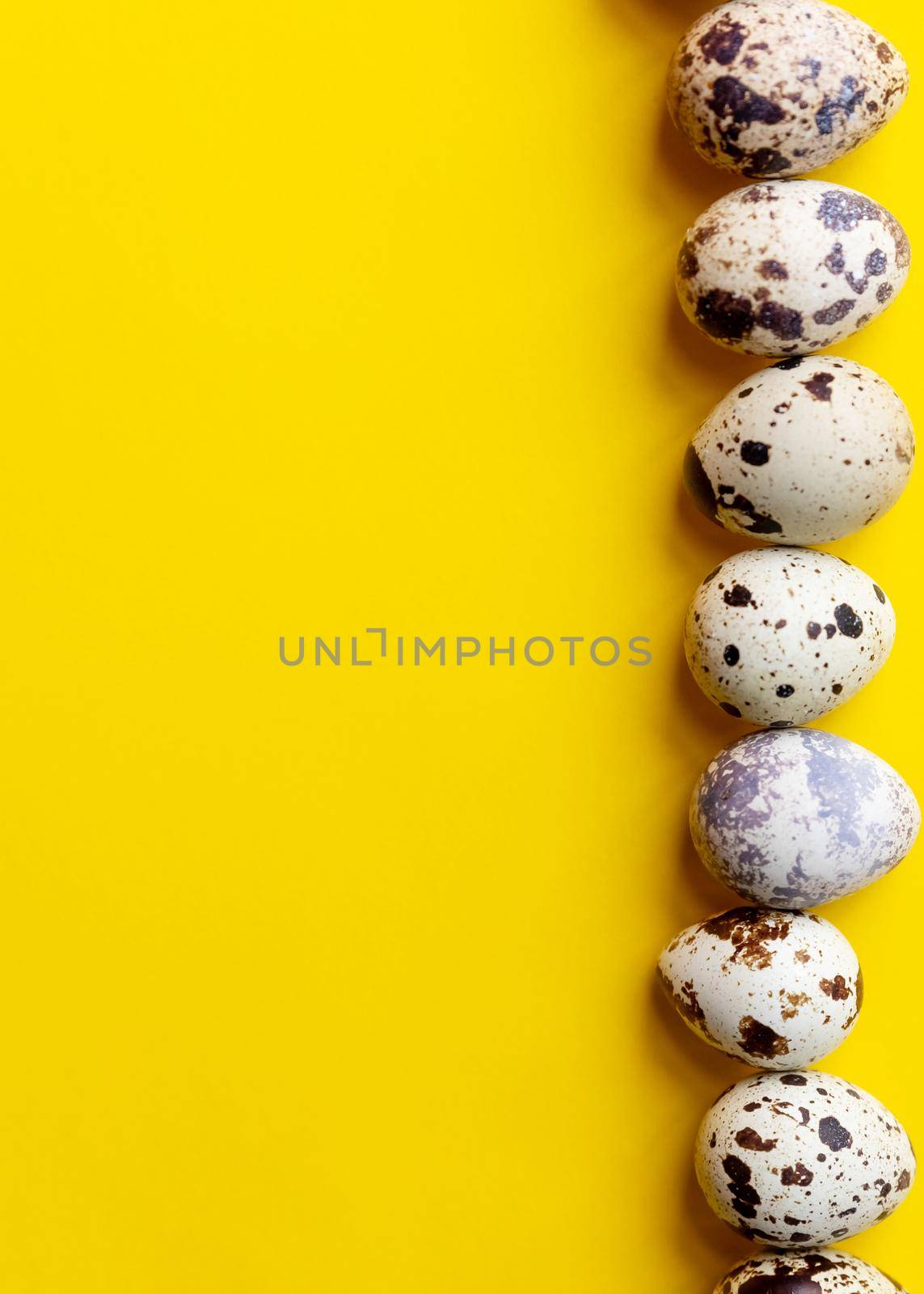 Top view ,Row of small speckled Quail eggs on yellow background. Minimal Happy Easter composition.healthy lifestyle diet concept. Copy space.organic natural egg. by YuliaYaspe1979