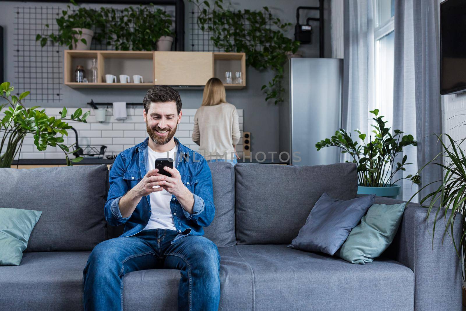 man has a secret communication correspondence with his mistress, sitting on the couch at home