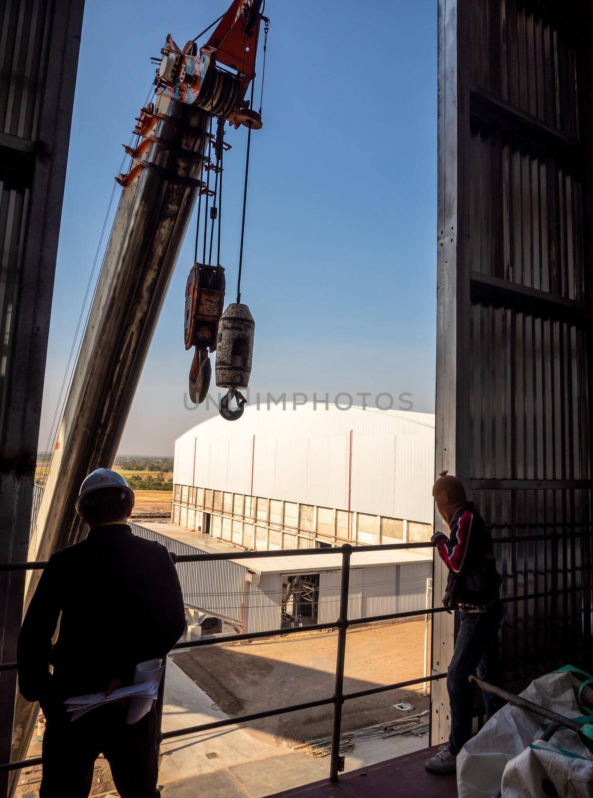 Hoist of crane at the window of industrial plant by Satakorn