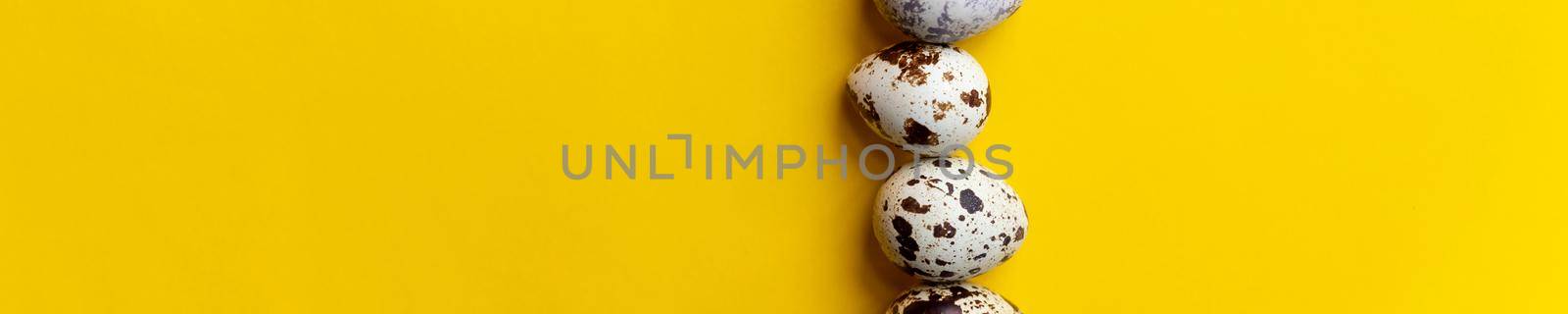 Top view ,Row of small speckled Quail eggs on yellow background. Minimal Happy Easter composition.healthy lifestyle diet concept. Copy space.organic natural egg.web banner by YuliaYaspe1979