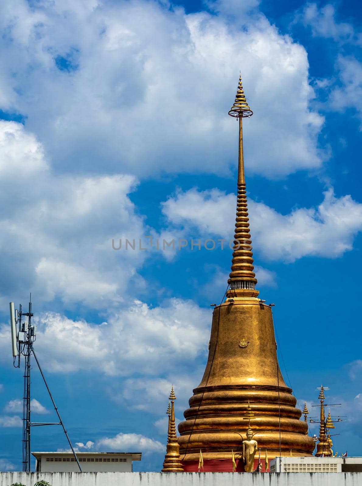 The golden pagoda is located in the city, towering to the sky by Satakorn