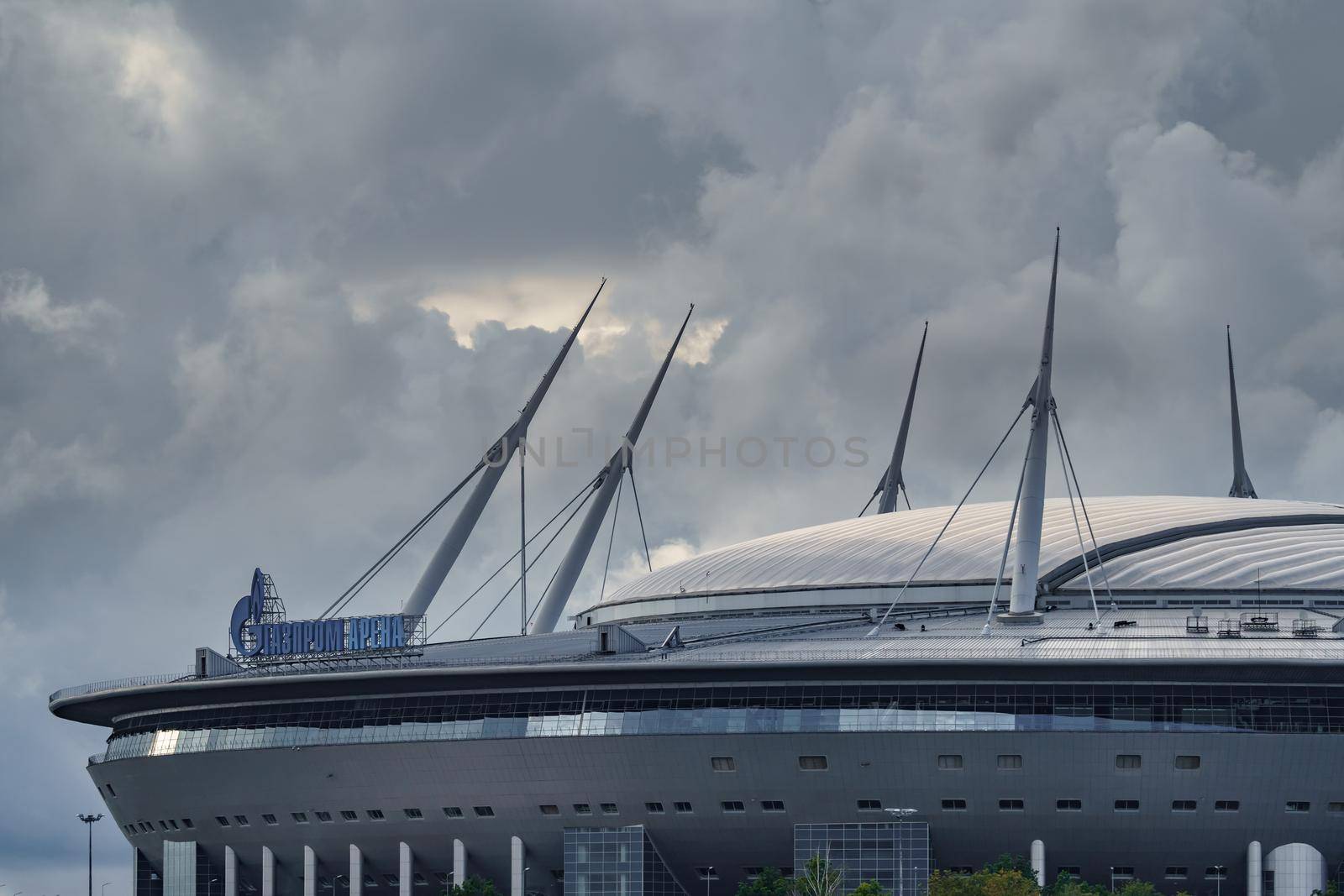 Russia, St. Petersburg, 29 July 2022: The new building of football stadium Gazprom Arena, the sliding metal roof glitters with spires in the sun, the gas company Gazprom. High quality photo