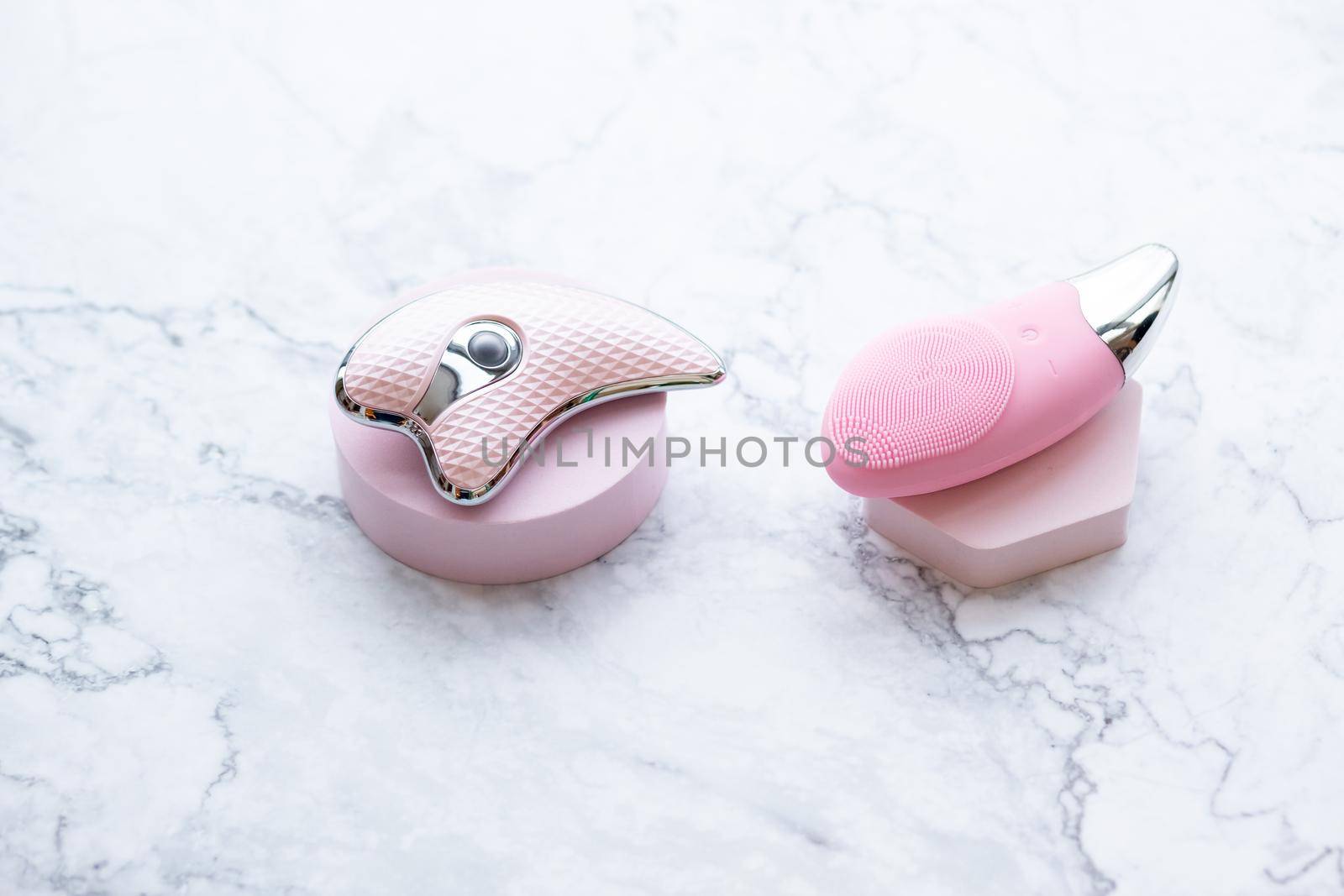 Ultrasonic Skin Scrubber Exfoliating Wand on pink background with bathroom items