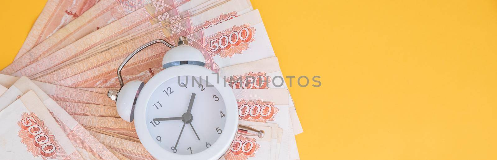 Time value of money concept, analog clock on US dollar banknote, depicting receiving money today can be poised to increase the future value by investing