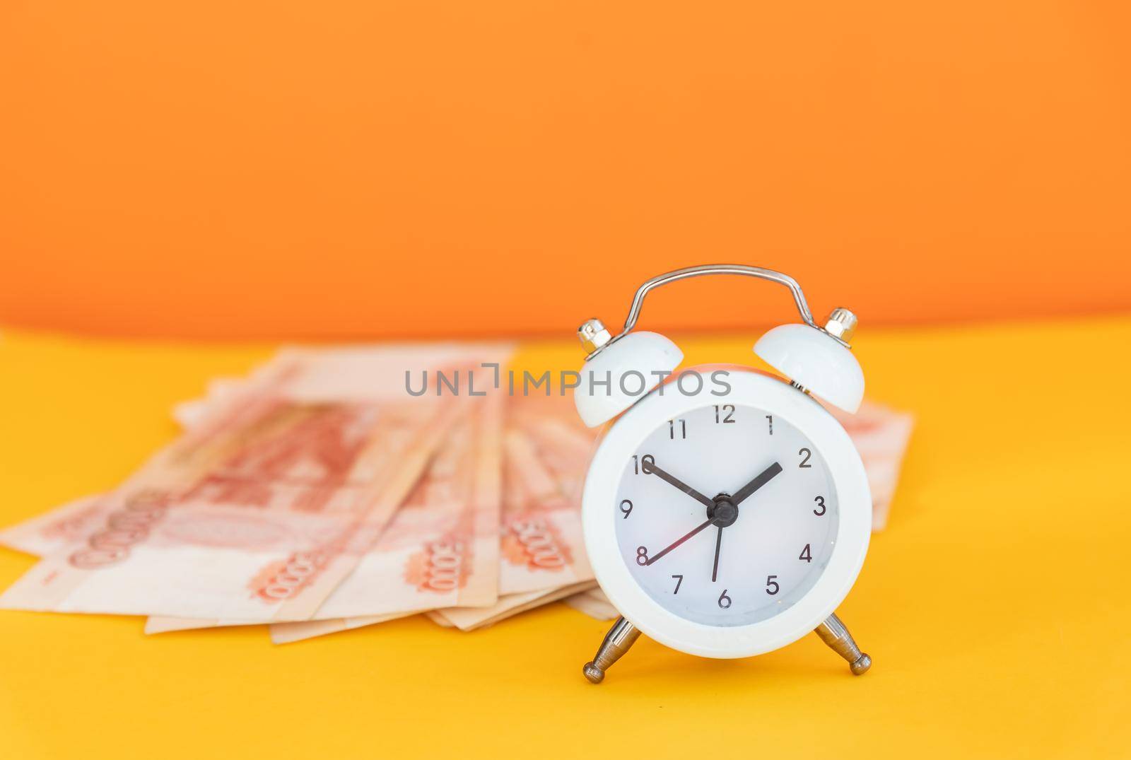 Time value of money concept, analog clock on US dollar banknote, depicting receiving money today can be poised to increase the future value by investing