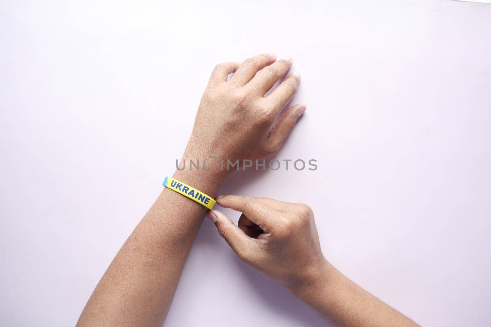 Hand with blue and yellow wristband , colors of flag of Ukraine