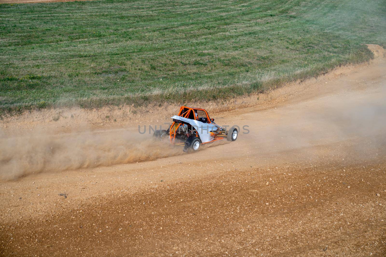buggies on the autocross track, skidding, dust and dirt flying under the tires.