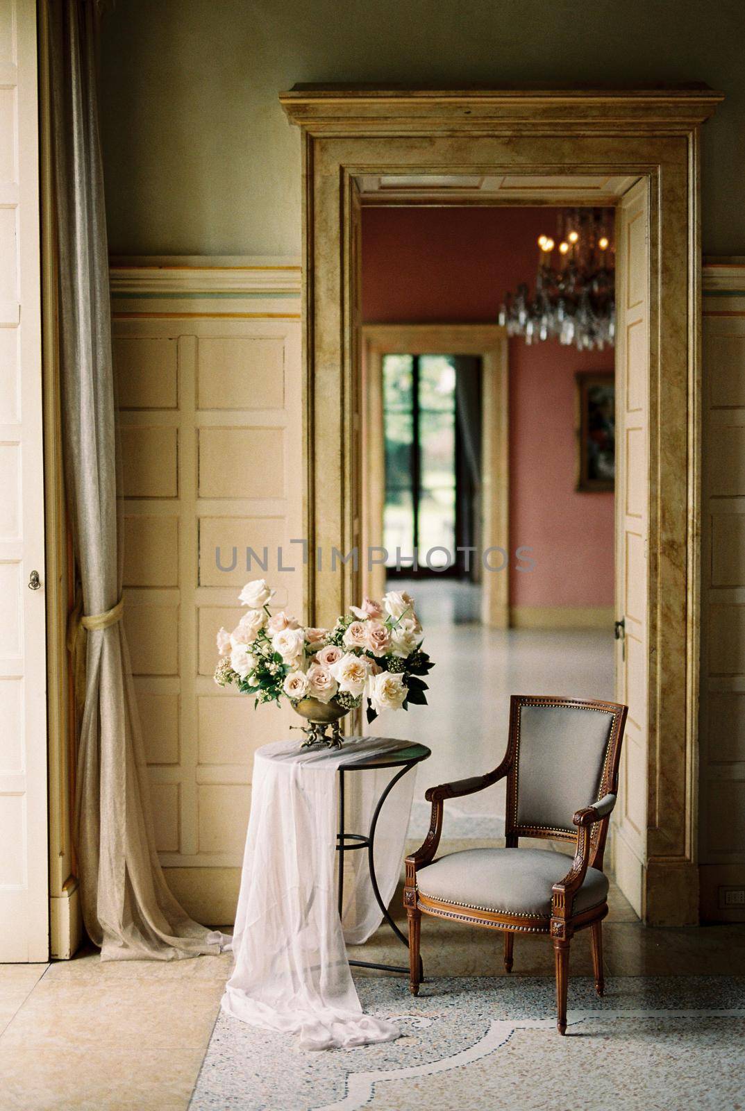 Bouquet of flowers on a table near an armchair in an old villa. High quality photo