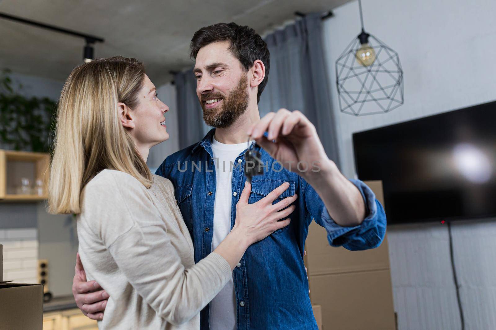 Close-up portrait of a young family, happy bought a new apartment, holding the keys to the house, happy