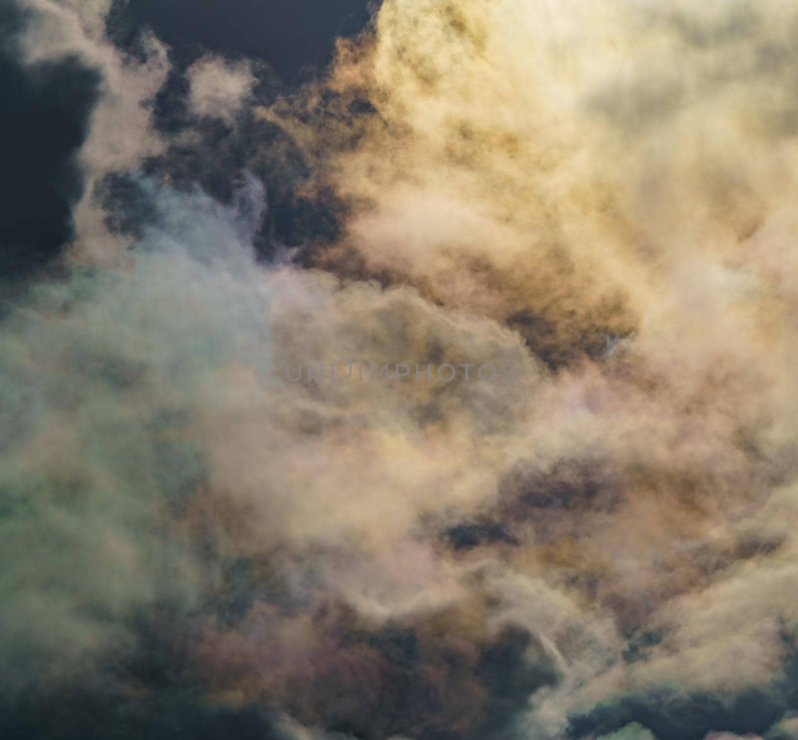 Diffraction of light on drops of supercooled water in clouds, rainbow clouds against the blue sky in clear sunny weather, irisation of cumulus clouds, optical phenomenon, spectral colors. High quality photo