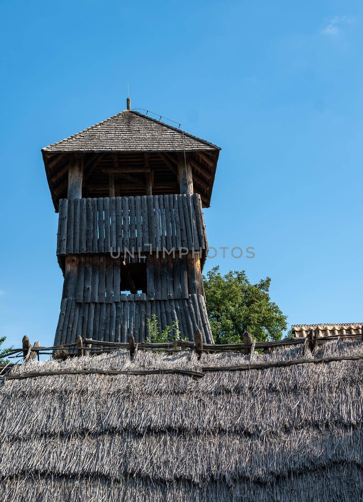 Museum of Old Slavs Modra. Watchtower against the background of the thatched roof of the cottage