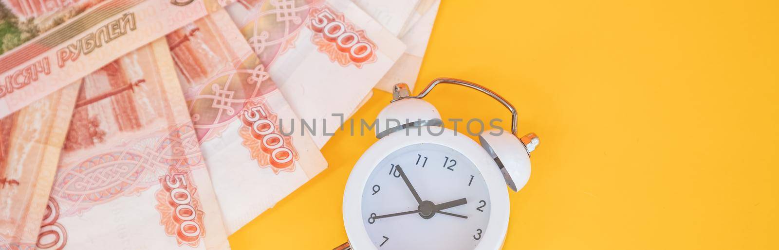 Time value of money concept, analog clock on US dollar banknote, depicting receiving money today can be poised to increase the future value by investing